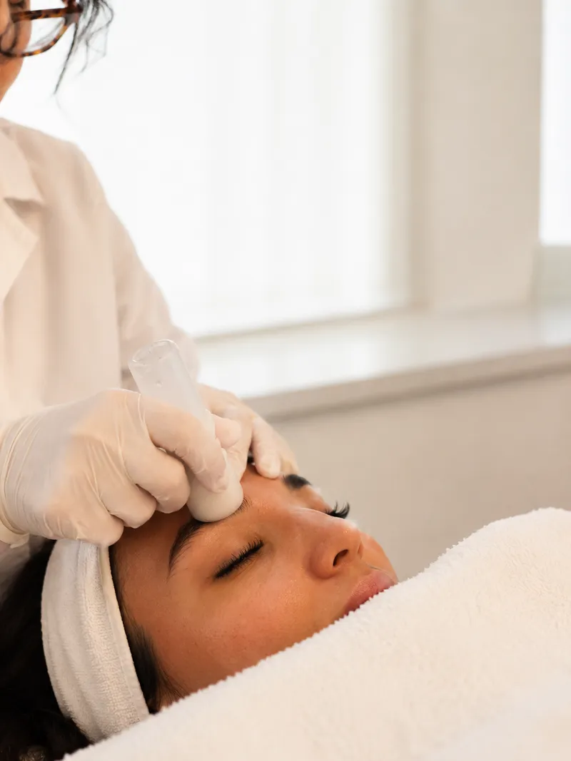 Practitioner performing a non-invasive facial treatment